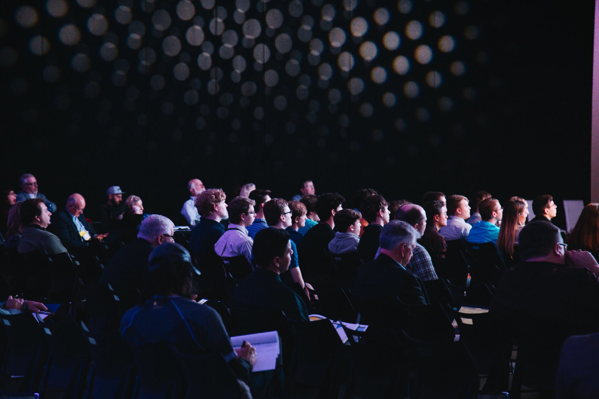 Group of people in a dark room attending a seminar