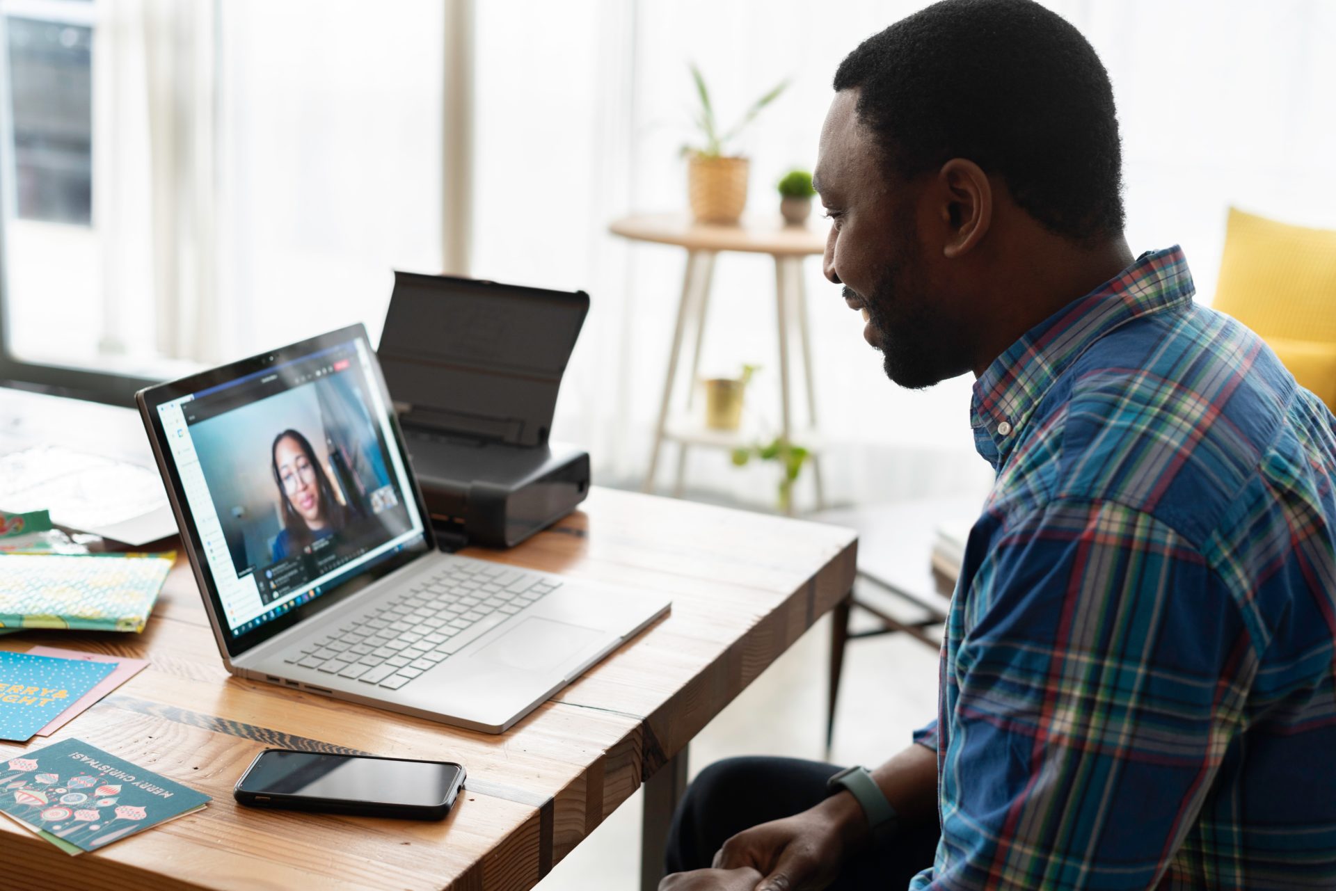 Man on a video call using laptop smiling man talking to woman on a video call using a laptop