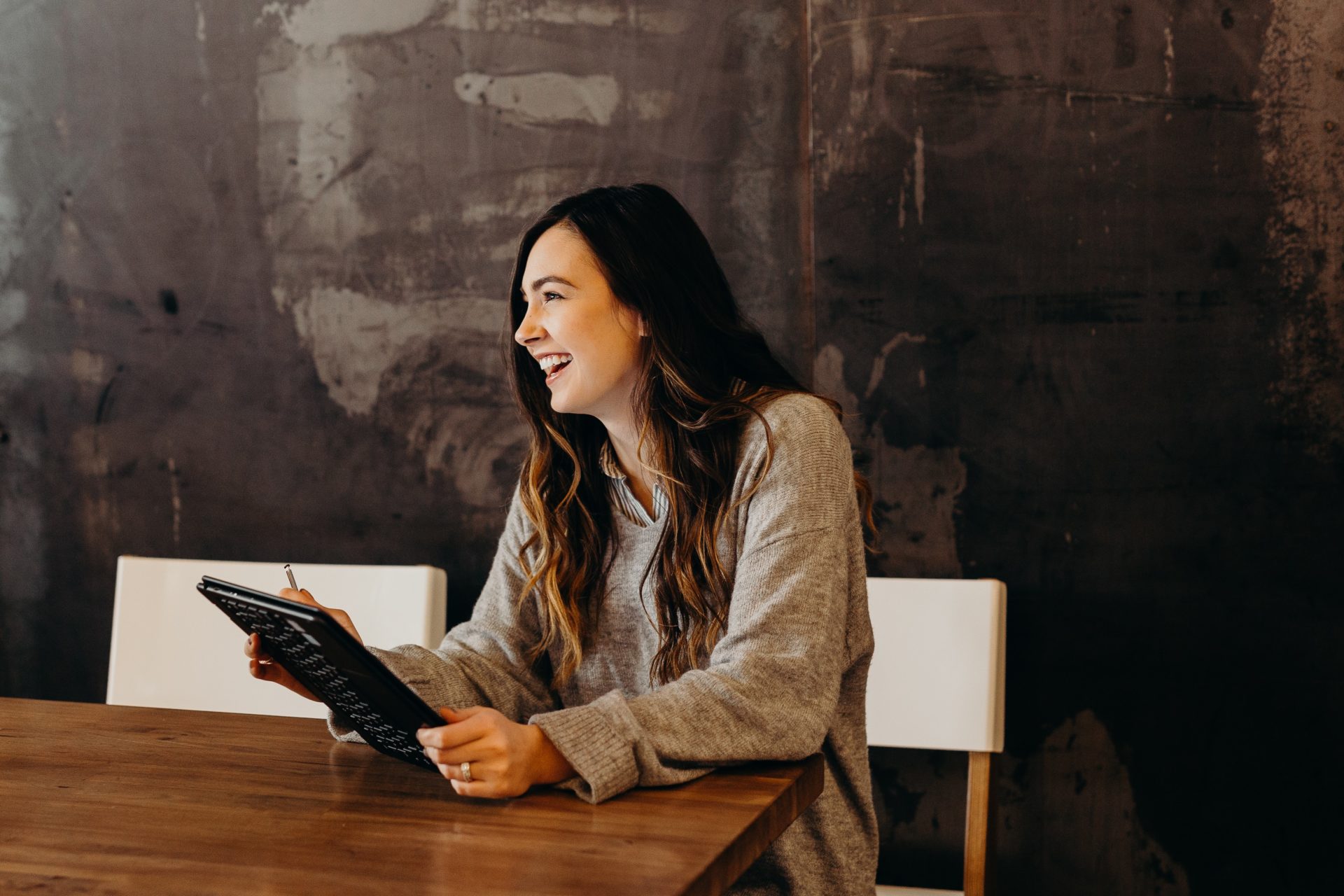 woman smiling and working on a tablet