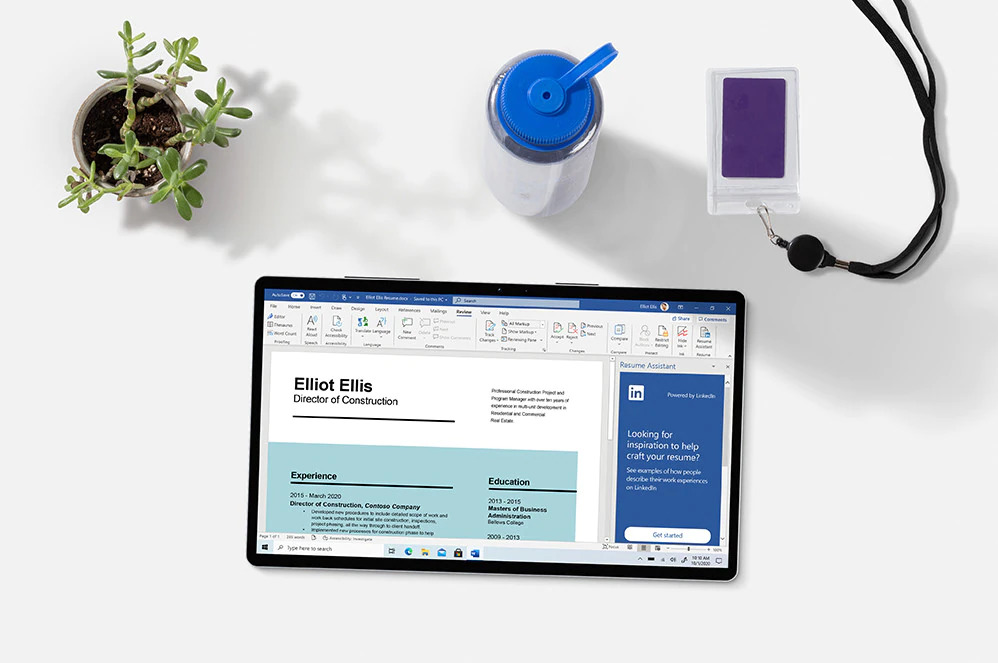 tablet with word document open of a CV on a desk with lanyard water bottle and plant