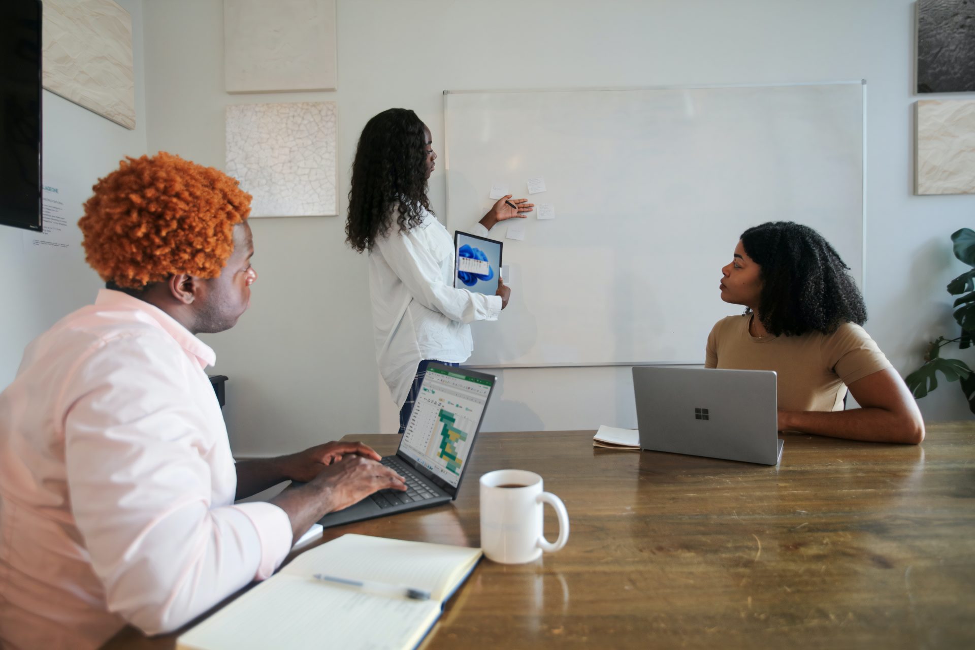 Woman presenting a meeting with two of her colleagues using Microsoft Surface Laptops