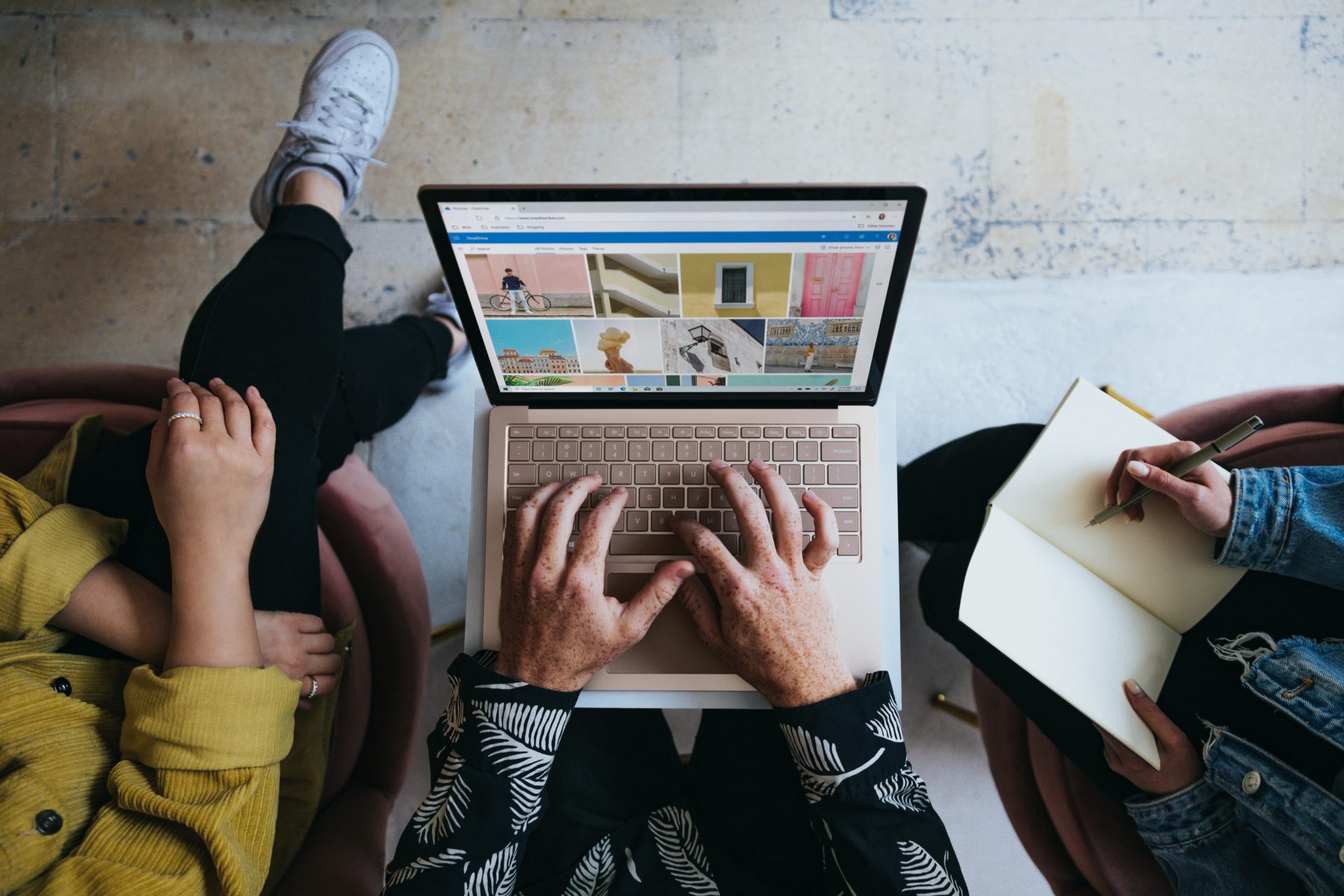 Birdseye view of man using a Microsoft Surface Laptop with two female co-workers