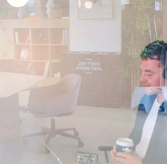 Man sat in a glass room on a Microsoft Teams video call