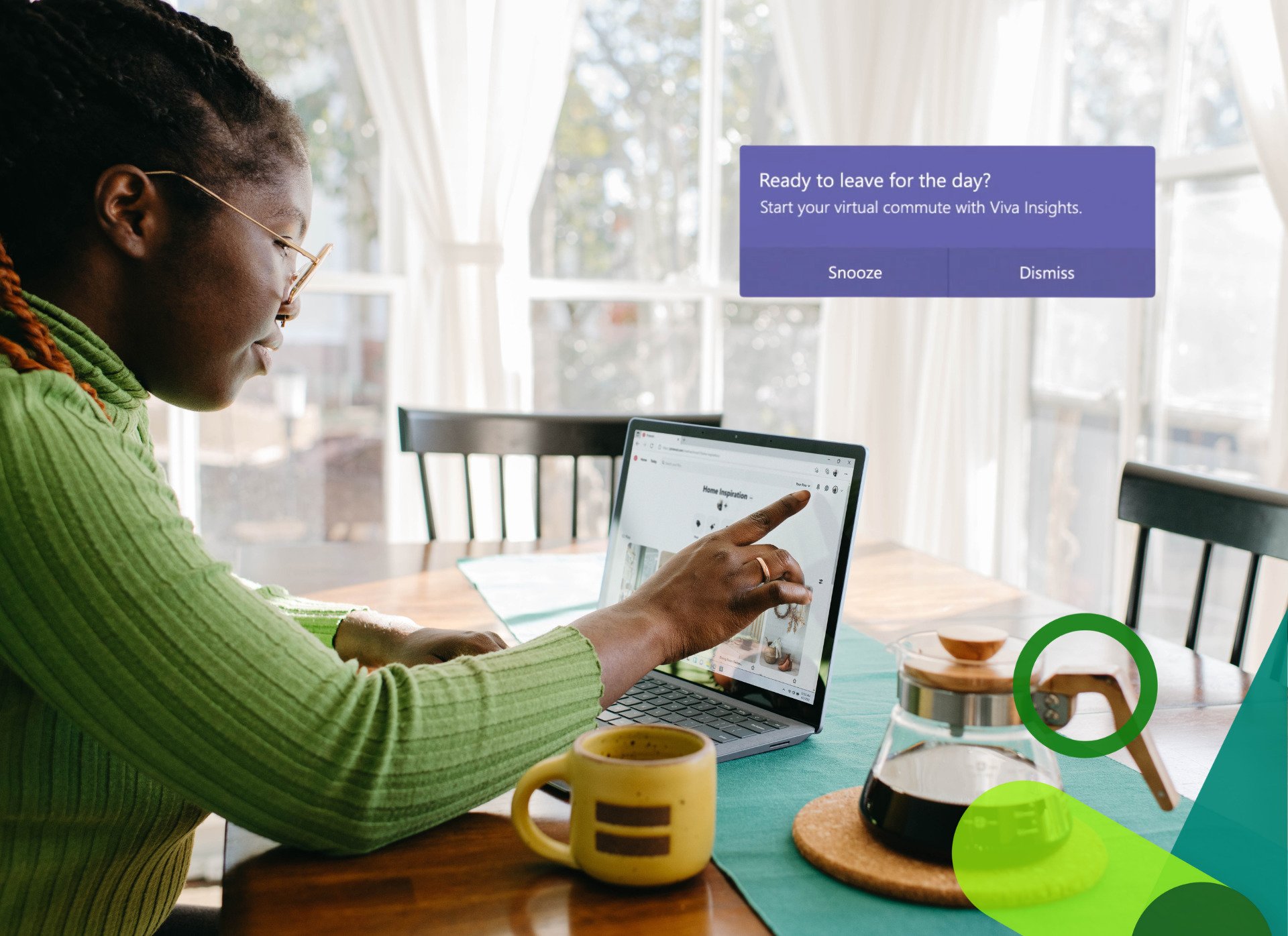 Woman using her touchscreen Surface laptop sat at her dinning room table