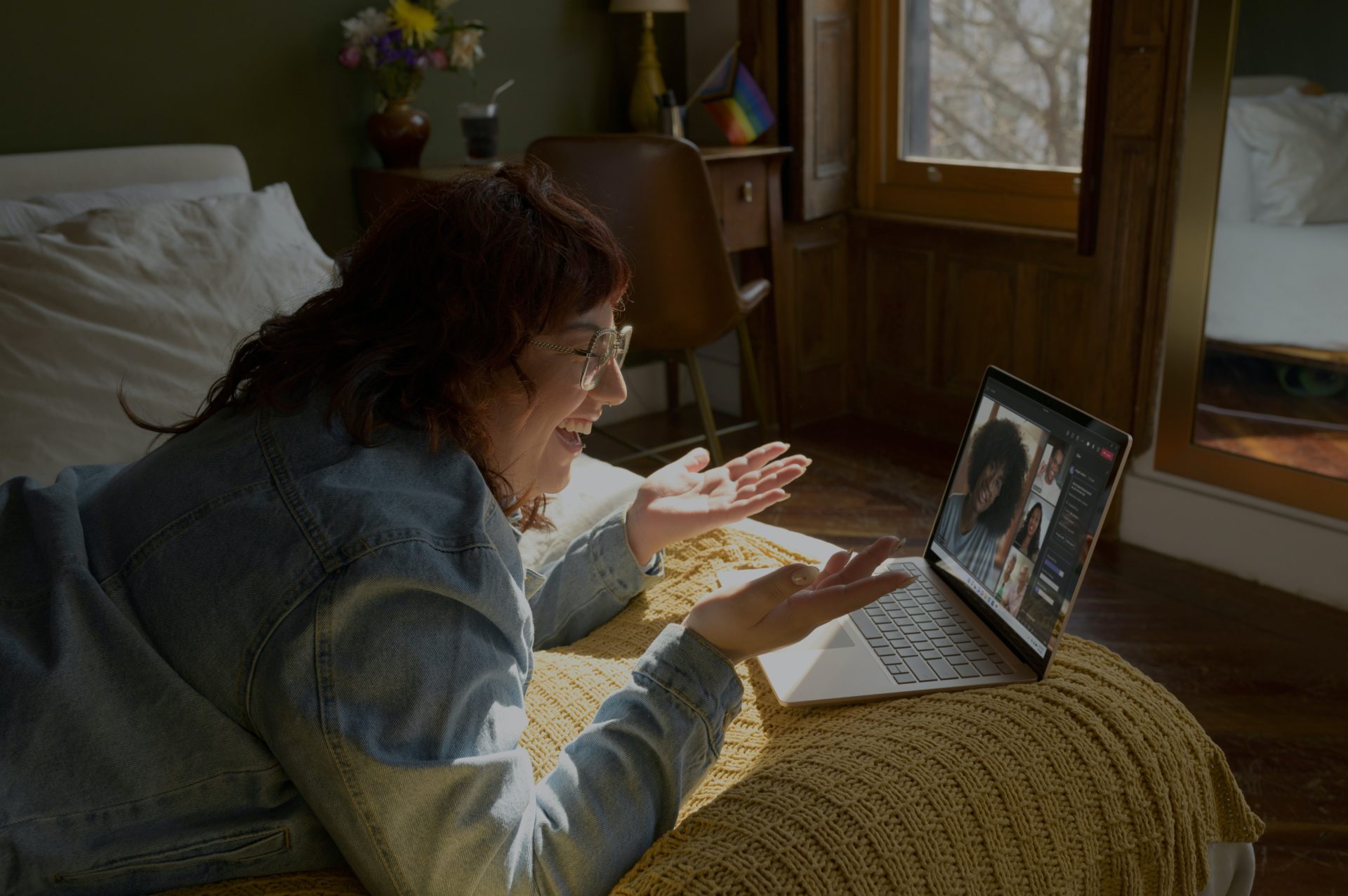 Smiling woman laying on her bed on a Microsoft Teams Video call discussing top tips for an automated business with colleagues