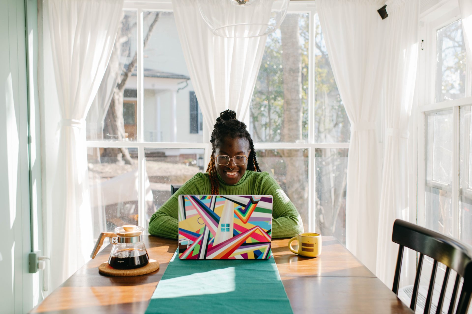 Smiling woman working from home on colourful Microsoft Surface Laptop