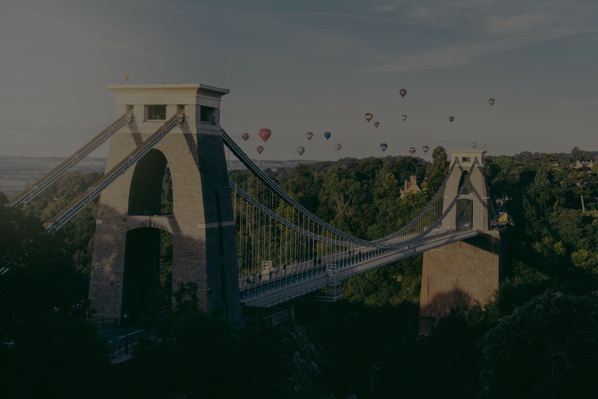 Clifton Suspension Bridge at Sunrise with a group of colourful hot air balloons in the background