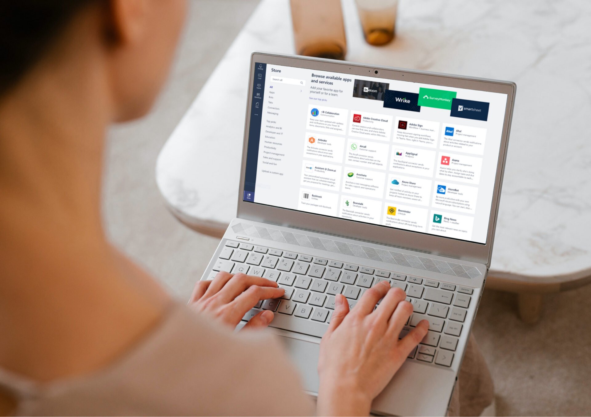 Teams App Article Header Image Woman looking at Microsoft Teams Apps in a laptop