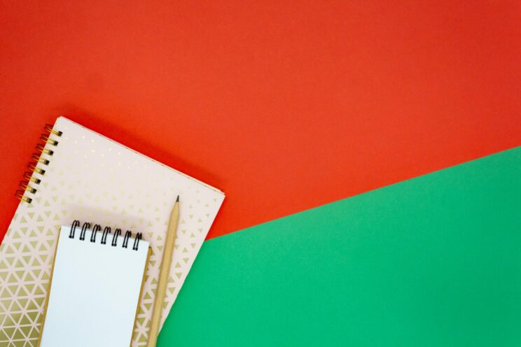 festive notepad and pencil on red and green background