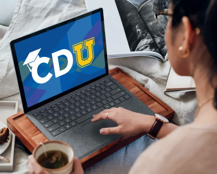 Laptop-in-the-hands-of-a-woman_CDU-Article-Image-744×595.jpg an image of an open laptop with the letters 'cdu' on the laptop