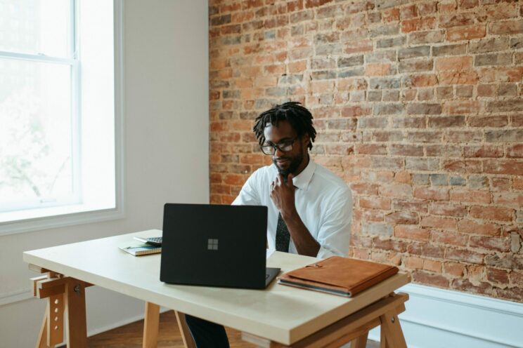 man working at desk with black windows laptop