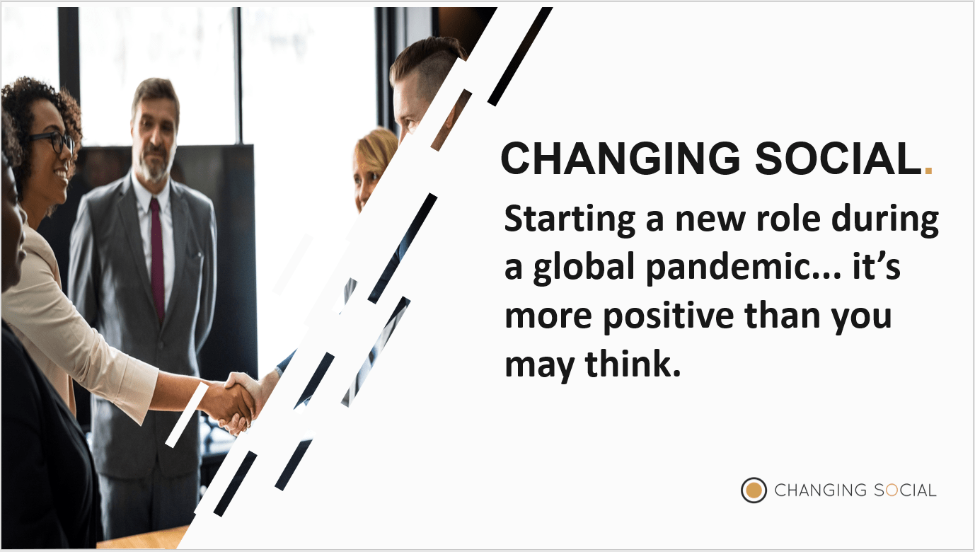 Starting New Role In A Pandemic a woman shaking hands with her male colleague in a group of corporate professionals