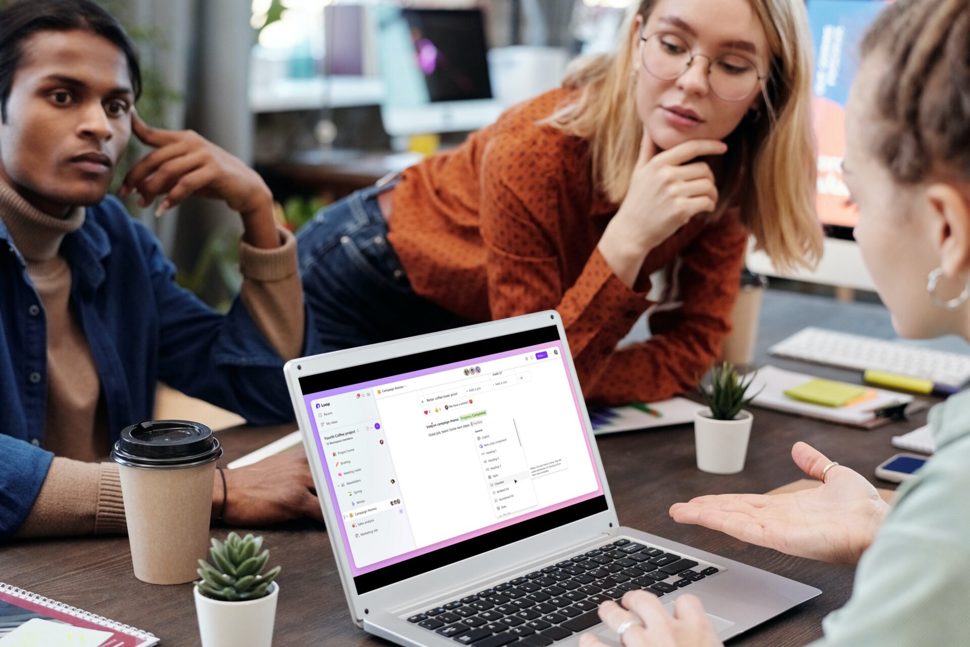 Woman using her laptop in a collaborative meeting, with MS Loop on the screen