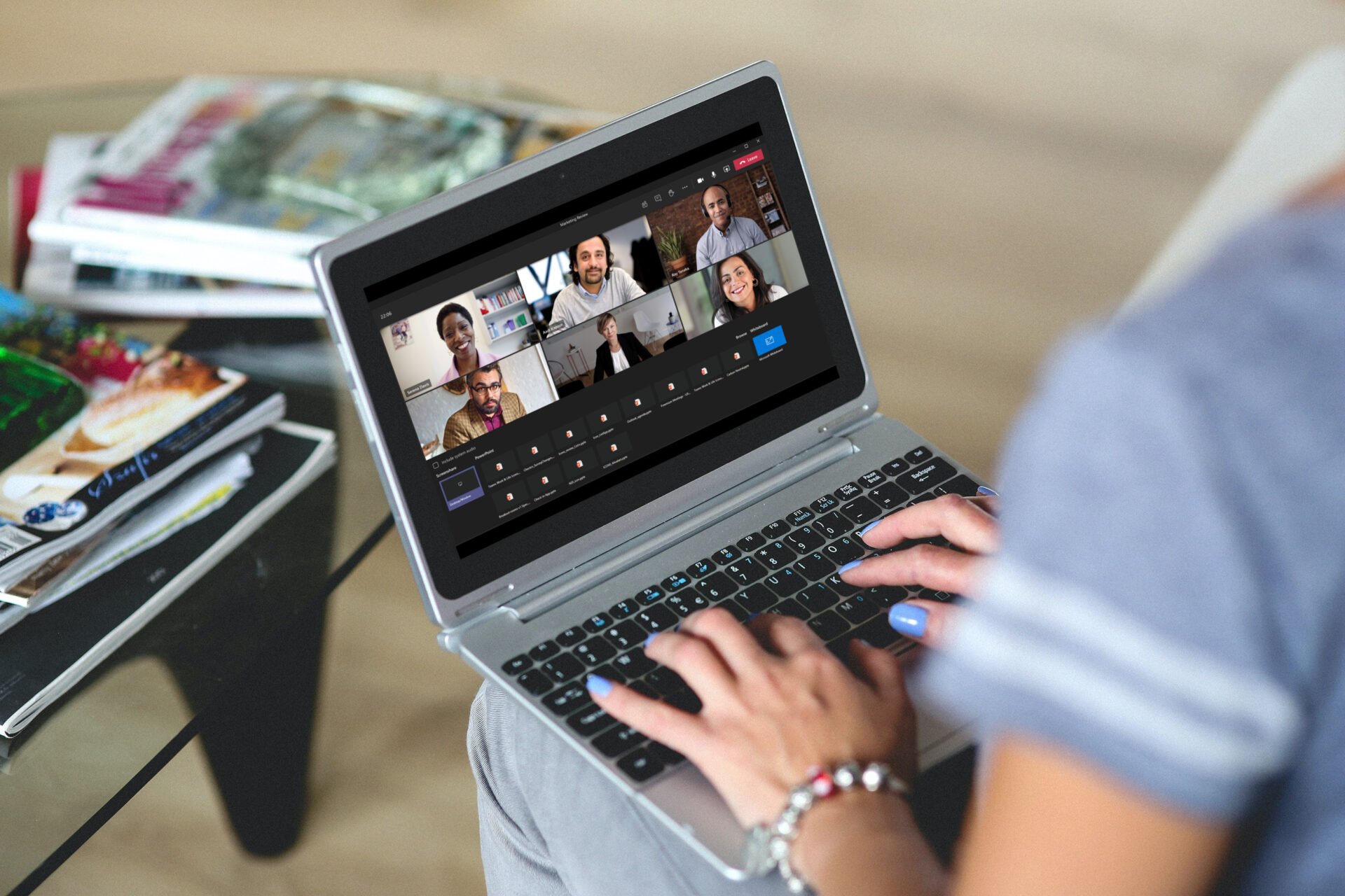 woman with laptop open on her lap, with a teams call on the screen