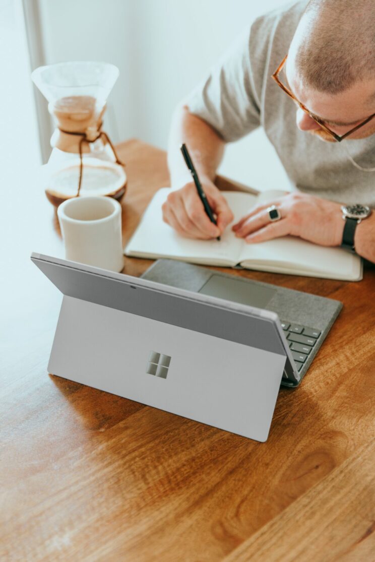 Microsoft Surface Tablet with man working at it with notepad