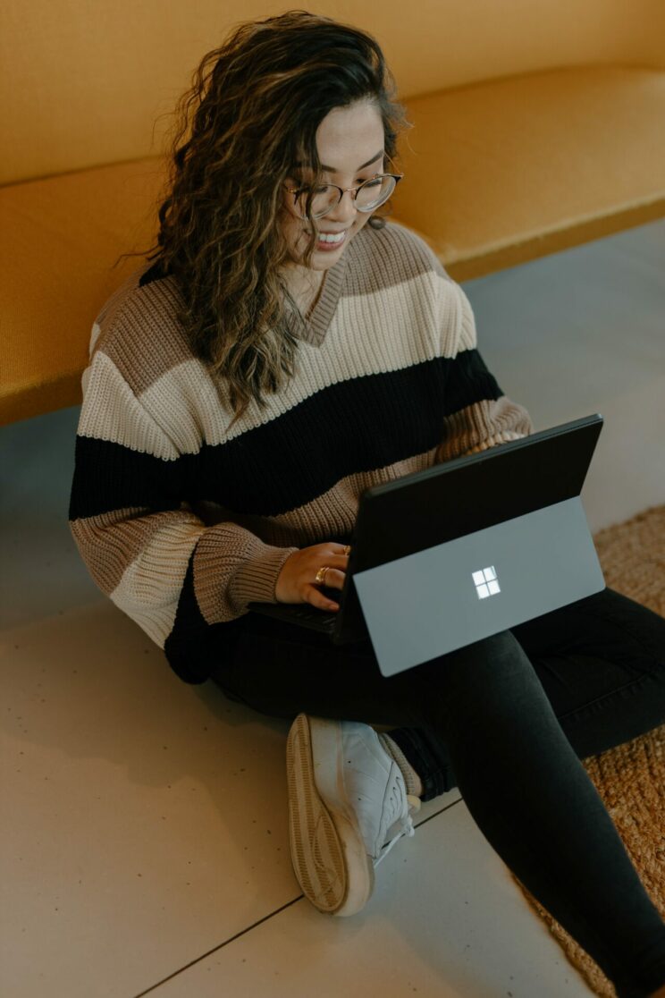 Student sat on the floor using a Microsoft Surface Tablet