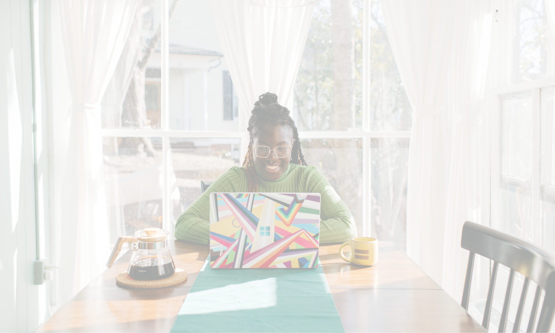 Smiling woman working from home on colourful Microsoft Surface Laptop