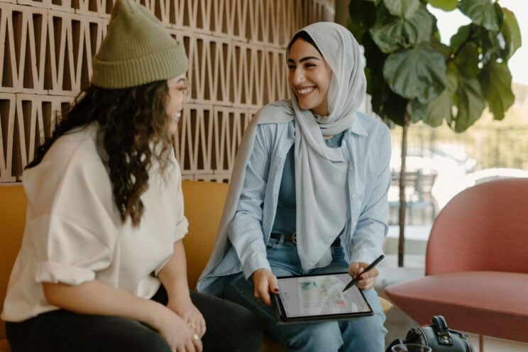 Microsoft 365 Meeting Two woman smiling during a meeting in a casual office space