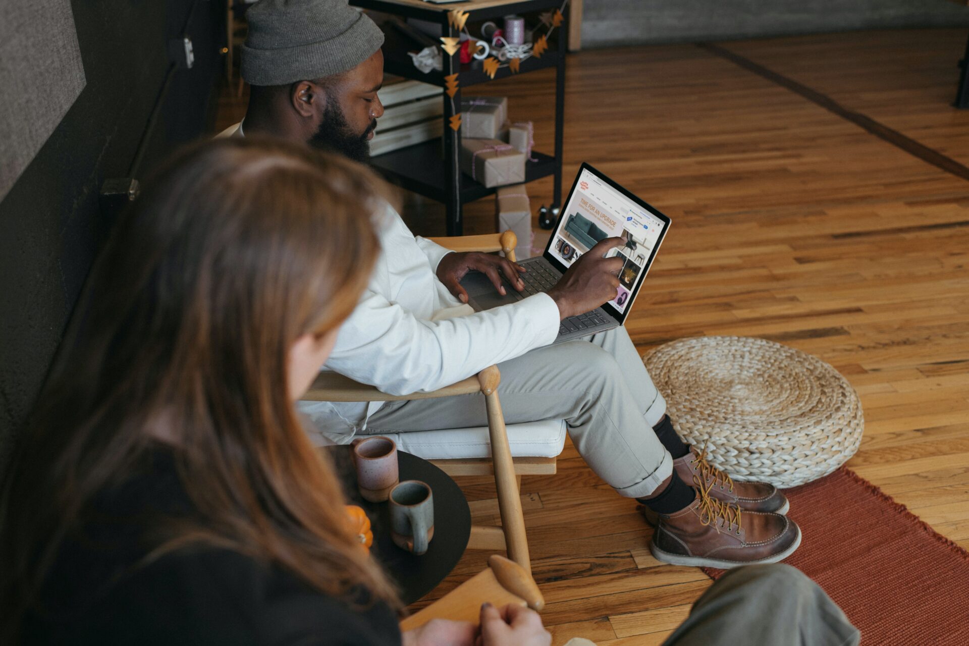 an image of a man and a woman sitting beside each other, both looking at something on the screen of the mans latpop