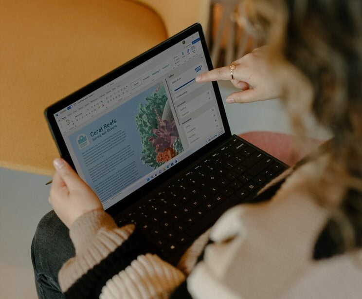 windows-Yi42MbW3Ayc-unsplash Woman on computer pointing at screen